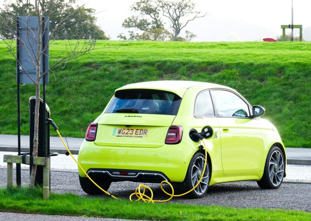 a yellow car is plugged into a charging station